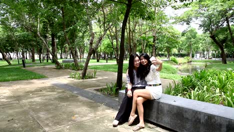 Female-friends-taking-photo-with-cellphone-in-garden