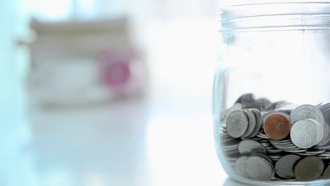 Falling-of-coins-to-glass-jar-concept-to-saving-money