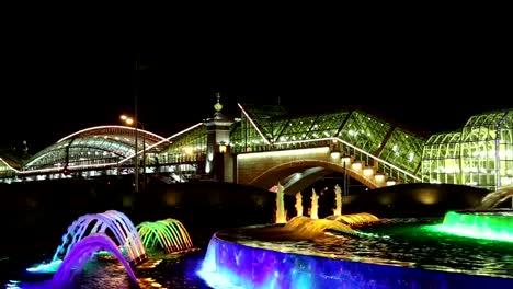 Square-of-Europe,-Animated-fountain-and-Kiyevskaya-railway-station--lit-at-night,-Moscow,-Russia