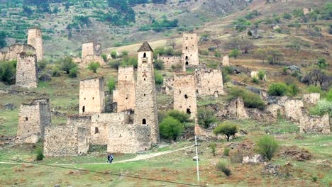 Anblick-Türme-und-Defensive-Türme-des-Nordkaukasus.-Historischen-mittelalterlichen-Monumentalbauten-in-den-Bergen.-Passanten-in-der-Nähe-von-historischen-Sehenswürdigkeiten-in-Inguschetien