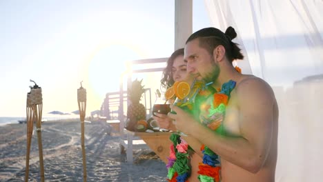 selfi-guy-and-girl-from-beach-an-exotic-resort,-photo-for-memory-from-tropical-islands,-friends-drink-cocktail-and-take-pictures-on-mobile