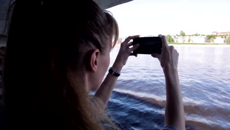 Chica-lanza-video-en-la-cámara-del-teléfono-durante-el-viaje-en-el-barco-en-el-río