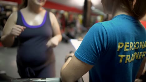 Fat-woman-working-out-in-gym-with-personal-trainer,-exercising-on-treadmill