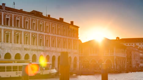 Visión-del-mercado-de-Rialto-desierta-en-timelapse-atardecer,-visto-desde-el-muelle-a-través-del-Gran-Canal-de-Venecia,-Italia