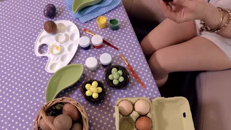 Mujer-en-la-mesa-de-Pascua-huevos-decorados