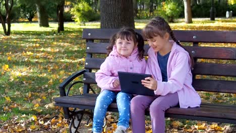 Kinder-mit-einem-Gadget-auf-die-Natur.-Kinder-spielen-mit-dem-tablet