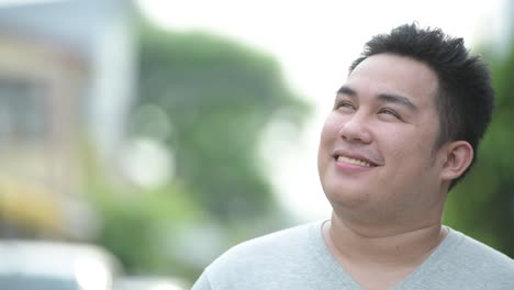 Young-handsome-overweight-Asian-man-in-the-streets-outdoors