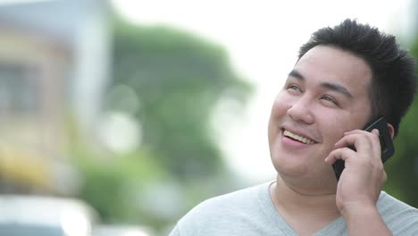 Young-handsome-overweight-Asian-man-in-the-streets-outdoors