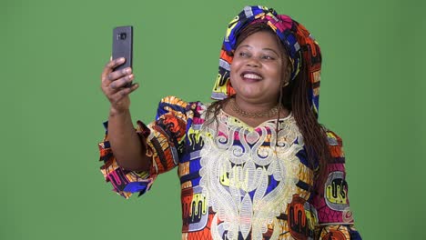 Overweight-beautiful-African-woman-wearing-traditional-clothing-against-green-background