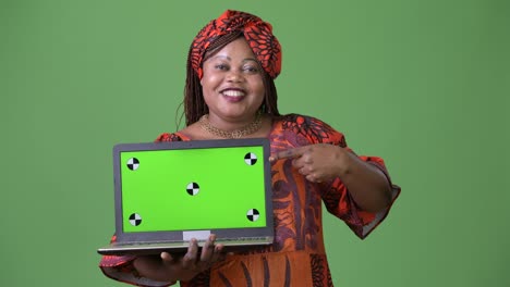 Overweight-beautiful-African-woman-wearing-traditional-clothing-against-green-background