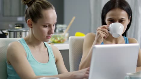 Mujer-mostrando-algo-en-la-computadora-portátil-a-pareja-femenina