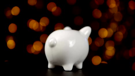 The-concept-of-charity-during-the-movember,-someone-puts-a-coin-in-piggy-bank.