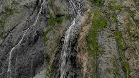 Tracking-and-top-shot-Air-shot-from-a-stream-of-water-splashing-waterfall-on-a-rock-wall-in-the-Caucasus-Mountains.-Around-the-jet-of-the-waterfall