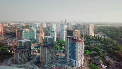 Aerial-drone-shot.-Construction-of-high-rise-buildings-in-the-developing-area-of-a-large-city.-construction-cranes-and-many-houses-under-construction