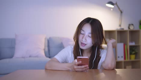 Asian-woman-using-cellphone-in-living-room