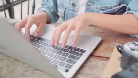 Negocio-freelance-mujer-asiática-trabajando,-haciendo-proyectos-en-portátil-y-usando-el-smartphone-mientras-está-sentado-en-la-mesa-de-café.-Estilo-de-vida-elegante-mujeres-hermosas-trabajando-en-conceptos-de-cafetería.