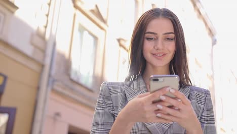 Beautiful-Woman-Using-Mobile-Phone-On-Street