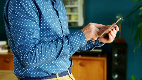 Businessman-Swiping-Through-Digital-Tablet-At-Home-Office