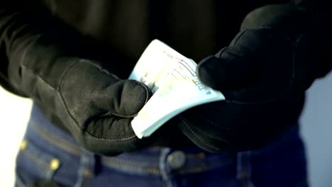 hombre-del-concepto-de-delito-en-los-guantes-de-cuero-negro-con-pila-de-dinero