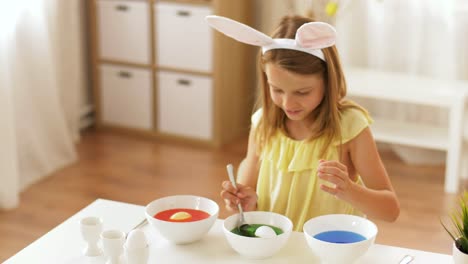 girl-coloring-easter-eggs-by-liquid-dye-at-home