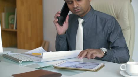 Businessman-Discussing-Chart-by-Phone