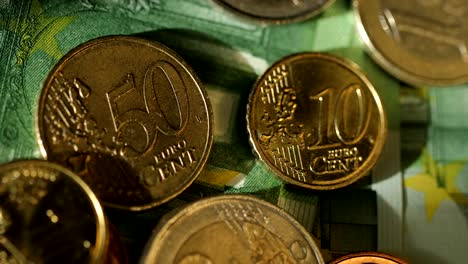 Tiro-de-cerca-de-euro-dinero,-monedas-y-billetes.-Moneda-euro.-Monedas-apiladas-entre-sí-en-diferentes-posiciones.-Concepto-de-dinero.-Rotación