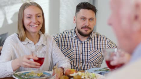 Ehepaar-klinkt-Brille-mit-Eltern-beim-Abendessen