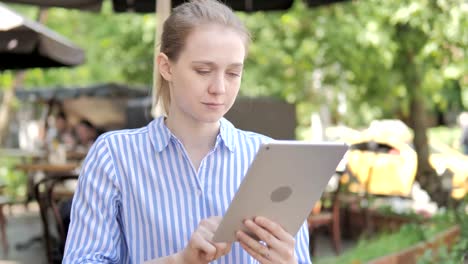 Mujer-joven-usando-la-tableta,-sentado-en-Cafe-Terrace