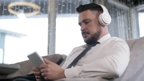 Hombre-de-negocios-caucásico-en-auriculares-usando-Tablet