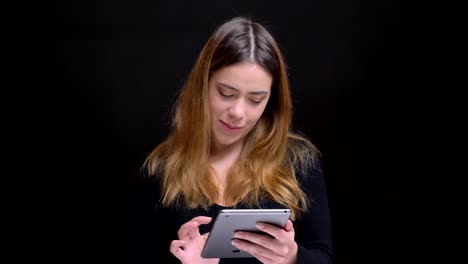 Closeup-portrait-of-young-beautiful-caucasian-female-typing-on-the-tablet-then-looking-at-camera-and-smiling