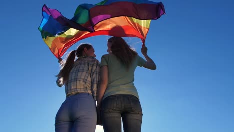 Junge-Lesben-mit-Flagge-stehen-im-Freien