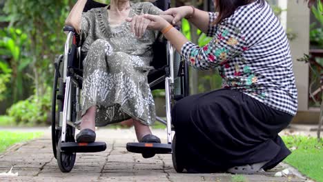 Hija-cuidar-madre-anciana-en-silla-de-ruedas-en-casa