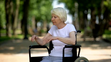 Anciana-deprimida-sentada-en-silla-de-ruedas-en-el-parque-del-centro-de-rehabilitación