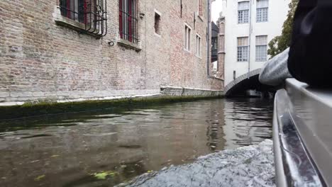 Bruges,-Belgium---May-2019:-View-of-the-water-channel-in-the-city-center.-Tourist-walk-on-the-water-canals-of-the-city.-View-from-a-tourist-boat.