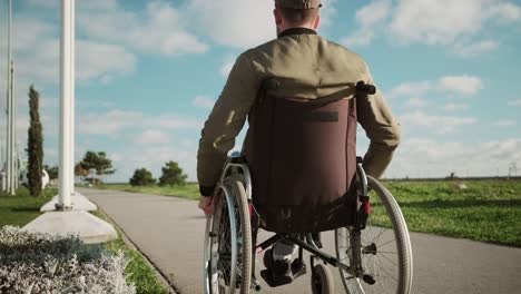 Outdoor-walk-of-disabled-man-in-wheelchair