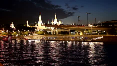 Schwimmende-Brücke-von-Zaryadye-Park-auf-Moskvoretskaya-Embankment-des-Flusses-Moskva-(und-touristisches-Vergnügungsboot)-bei-Nacht.-Moskau,-Russland.