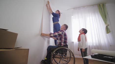 beloved-disabled-in-wheelchair-happy-person-chooses-young-beautiful-wife-new-wallpaper-in-room-during-repair