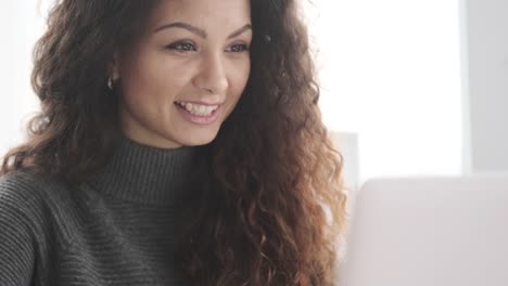 Glückliche-Frau-mit-Laptop-im-Büro