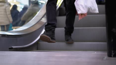 Legs-of-People-Moving-on-an-Escalator-Lift-in-the-Mall.-Shopper's-Feet-on-Escalator-in-Shopping-Center