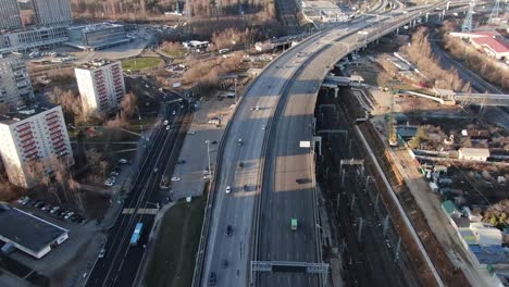 Vista-aérea-paisaje-urbano-de-carretera-de-alta-velocidad-con-coches-en-movimiento-en-un-hermoso-día-soleado.-Disparo-desde-un-dron