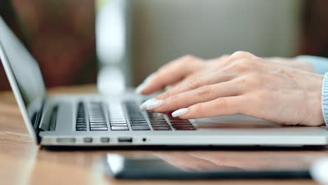 Female-hands-typing-on-keyboard-of-laptop-pc-working-side-view.-Close-up-shot-on-4k-RED-camera