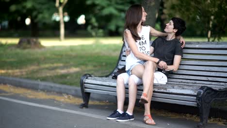 Two-happy-lesbians-meeting-on-bench-and-kisses