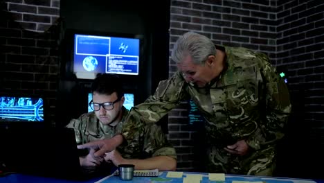 chief-and-soldier-in-camouflage-uniform,-at-briefing,-in-monitoring