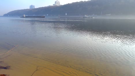 Fluss-mit-Binnenschiffen-an-einem-nebeligen-Tag