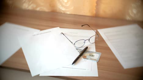 Testament-documents,-glasses,-money-and-pen-on-the-table.