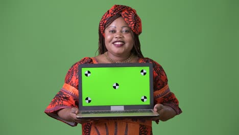 Overweight-beautiful-African-woman-wearing-traditional-clothing-against-green-background