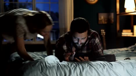 Young-couple-surfing-smartphone-on-bed