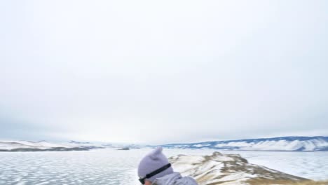 Viaje-de-la-mujer-en-el-hielo-del-lago-Baikal.-Cierre-único-budista-stupa-burkhan-monumento-símbolo-místico-isla-ritual-histórico-Ogoi-paisaje-montañas-chamánica-adoración.-Viaje-a-la-isla-de-invierno.