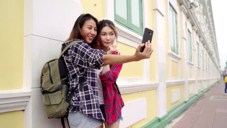 Reisender-Backpacker-asiatische-Frauen-Lesben-LGBT-paar-Reisen-in-Bangkok,-Thailand.-Glückliche-Blogger-junges-weibliches-Paar-mit-Smartphone-für-Selfie.