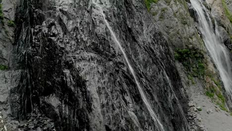 Tracking-und-oben-geschossen-Luft-aus-einem-Strom-von-Spritzwasser-Wasserfall-auf-einer-Felswand-in-den-Bergen-des-Kaukasus-gedreht.-Nahe-der-Jet-des-Wasserfalls